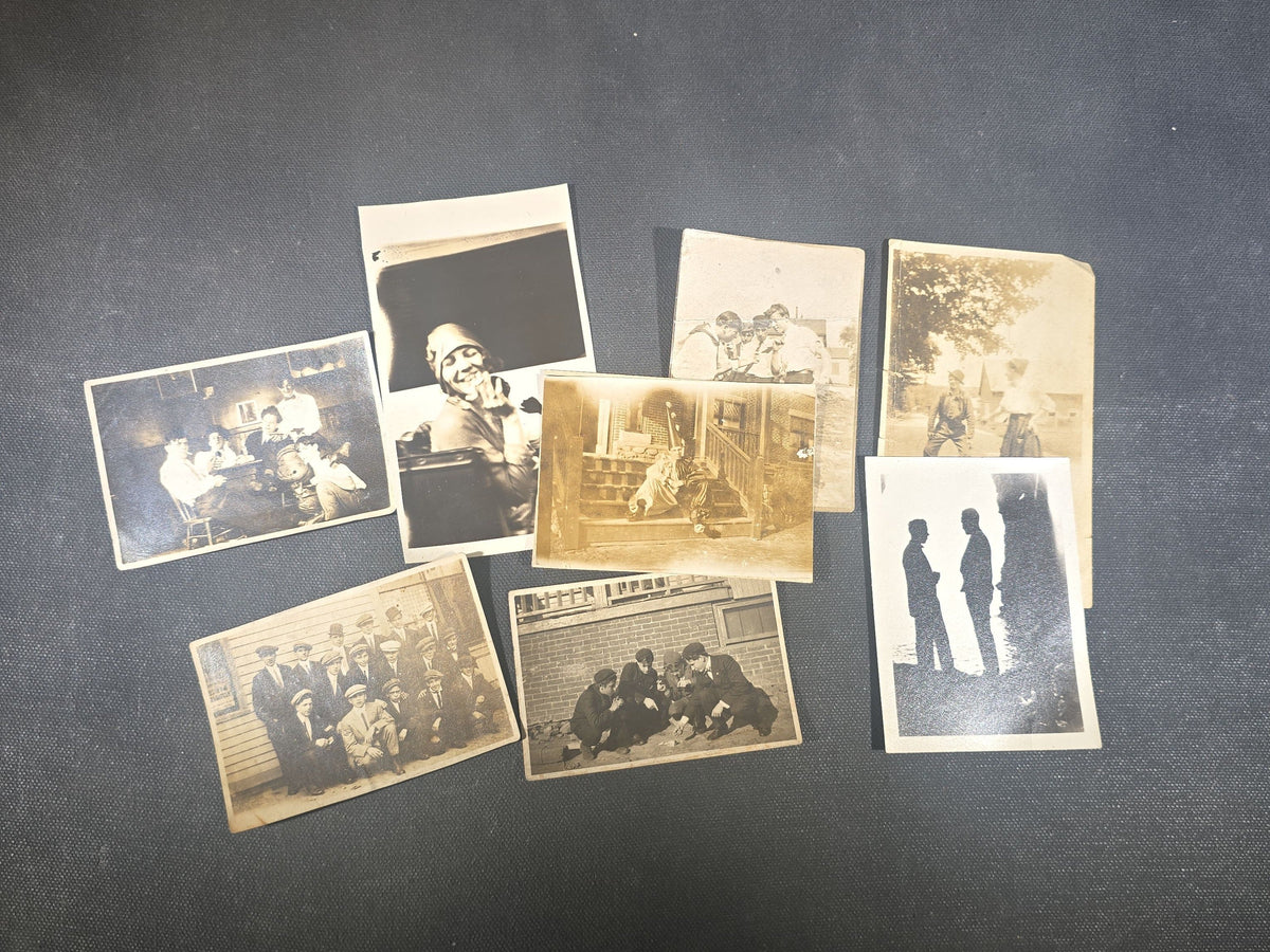 Grouping of Eight Antique and Vintage Snapshot Photographs including Boys Gambling on a Sidewalk, Clown on Stoop, Silhouette of Two Figures on a Shore, and a Group Portrait Outside