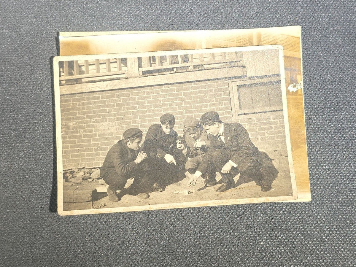 Grouping of Eight Antique and Vintage Snapshot Photographs including Boys Gambling on a Sidewalk, Clown on Stoop, Silhouette of Two Figures on a Shore, and a Group Portrait Outside