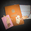 Lot 017 - Vintage WWII U.S. Service Writing Kit with Contents Including "Armoreader" Camp Polk, Louisiana Newsletter, "The Communique" Newsletter, Chemical Warfare Pocket Reference Card, and Die-Cut Kewpie Christmas Ornaments