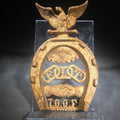 Lot 007 - Antique Cast Iron Independent Order of Odd Fellows I.O.O.F. Horseshoe Ornament with Eagle, All-Seeing Eye, Three-Link Chain "F.L.T.," And Clasped Hands, 7" H