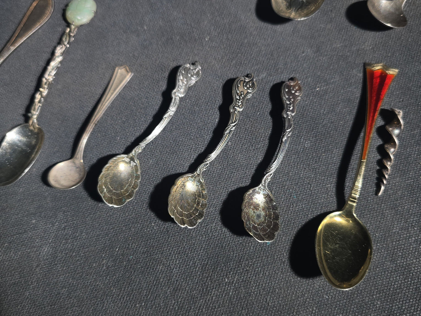 Grouping of 24 Antique and Vintage Sterling, 800 Silver, and Silver-Plated Souvenir and Collector's Spoons and Cutlery including 23 Spoons and One Fork