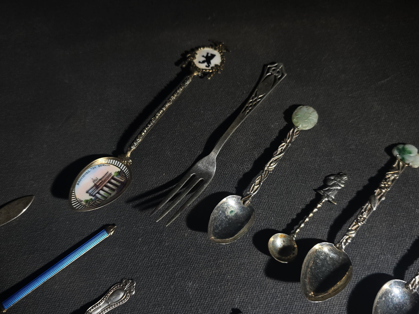 Grouping of 24 Antique and Vintage Sterling, 800 Silver, and Silver-Plated Souvenir and Collector's Spoons and Cutlery including 23 Spoons and One Fork