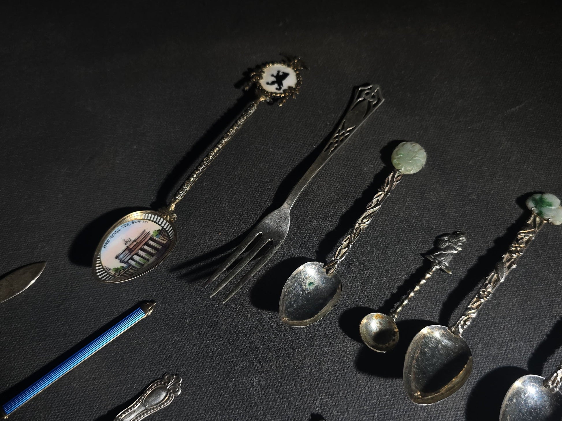 Grouping of 24 Antique and Vintage Sterling, 800 Silver, and Silver-Plated Souvenir and Collector's Spoons and Cutlery including 23 Spoons and One Fork