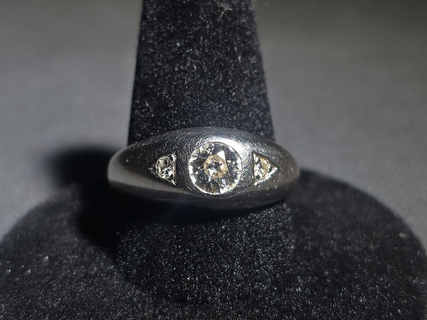 14K White Gold Three-Stone Diamond Ring with Flush-Set Center Stone and Triangular Side Settings