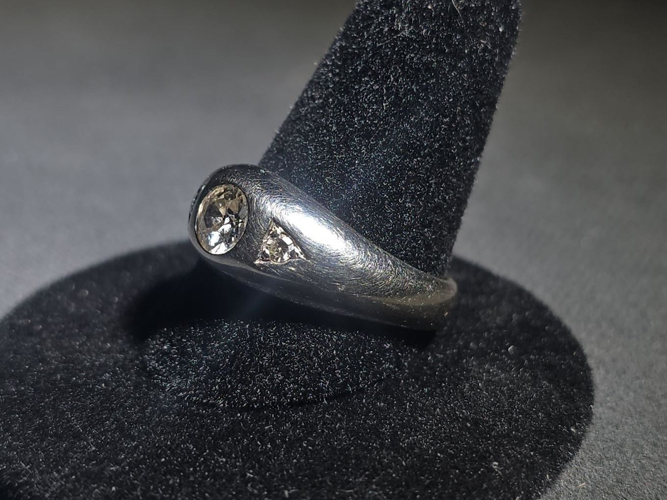 14K White Gold Three-Stone Diamond Ring with Flush-Set Center Stone and Triangular Side Settings