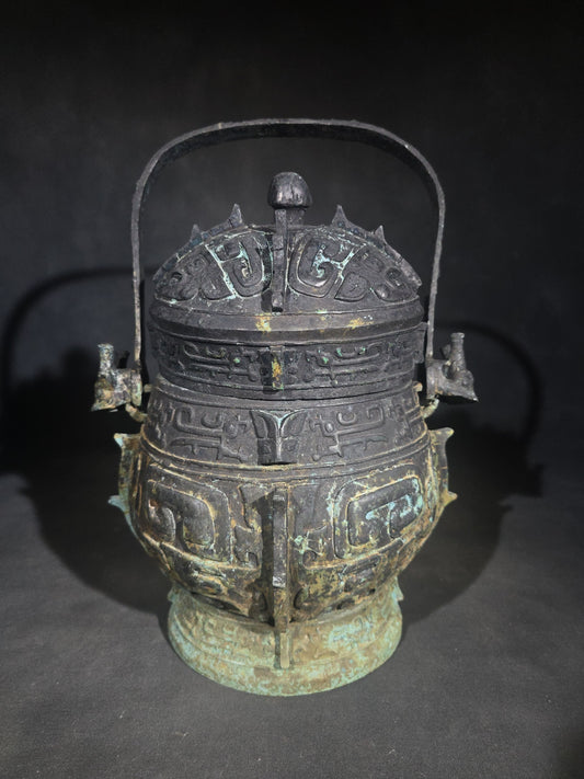 Antique Chinese Bronze You Vessel Reproduction with Taotie Mask Decoration, Swing Bail Handle, and Lidded Top