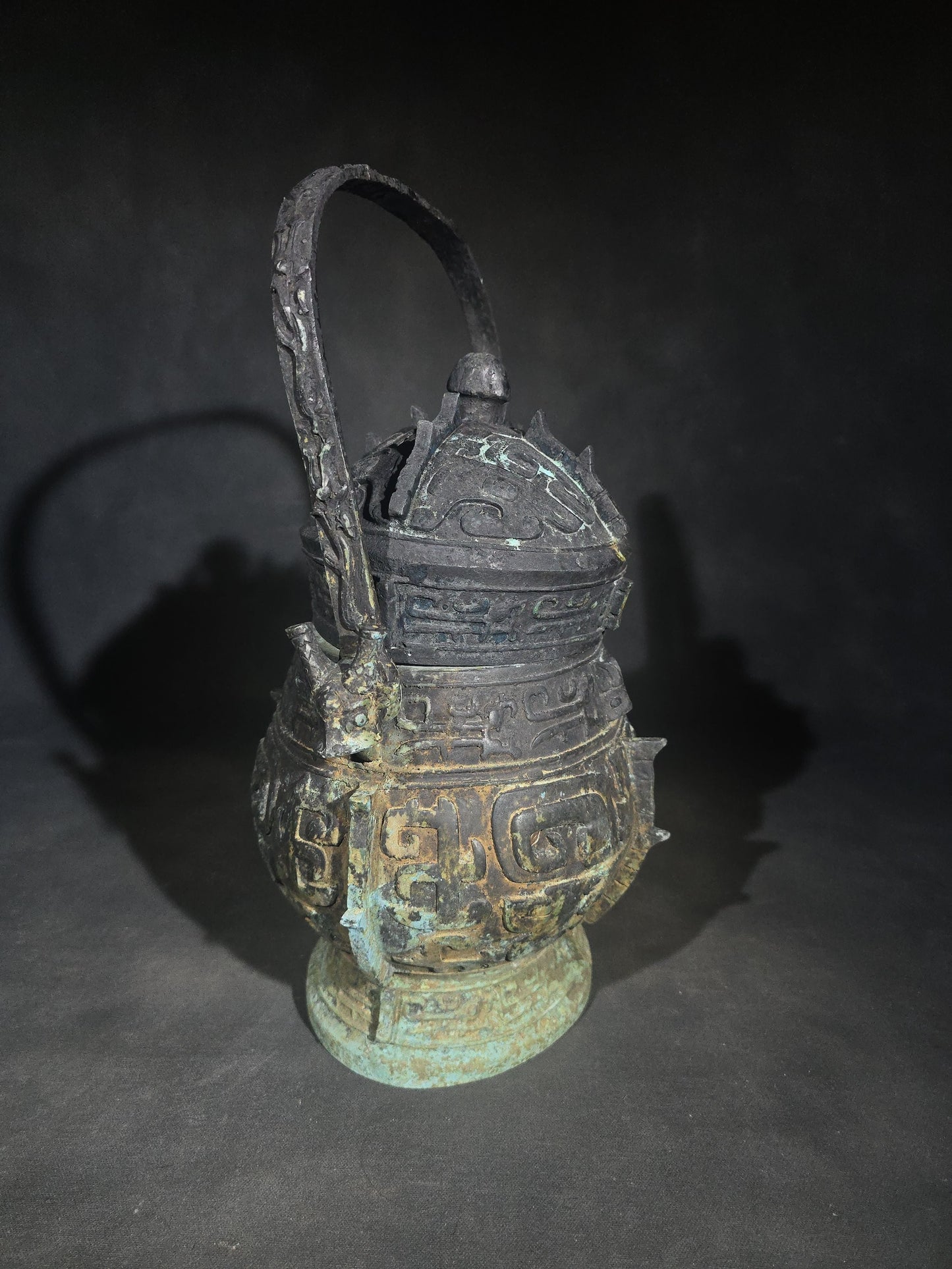 Antique Chinese Bronze You Vessel Reproduction with Taotie Mask Decoration, Swing Bail Handle, and Lidded Top