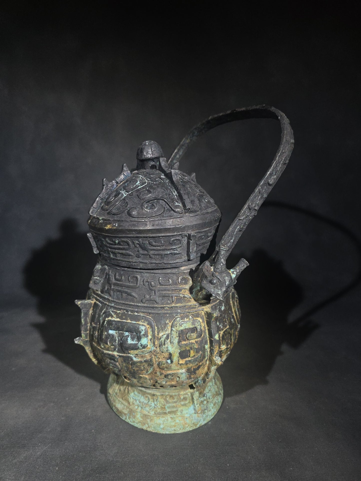 Antique Chinese Bronze You Vessel Reproduction with Taotie Mask Decoration, Swing Bail Handle, and Lidded Top