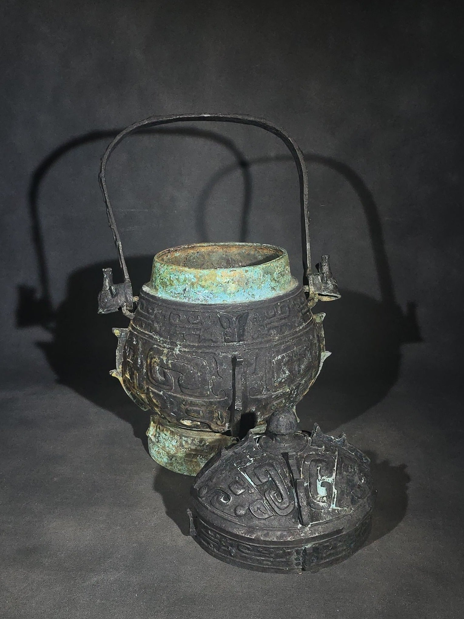 Antique Chinese Bronze You Vessel Reproduction with Taotie Mask Decoration, Swing Bail Handle, and Lidded Top