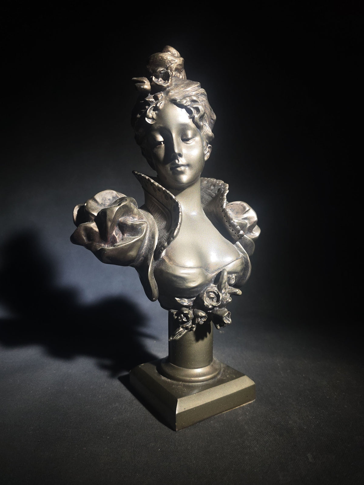 Vintage Art Nouveau Style Bust of a Young Woman with Upswept Hair, Ruffled Collar, and Rose Spray on Pedestal Base