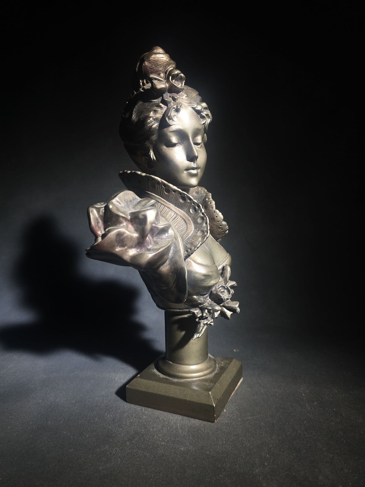 Vintage Art Nouveau Style Bust of a Young Woman with Upswept Hair, Ruffled Collar, and Rose Spray on Pedestal Base