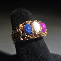 Lot 021 - 14k Gold Nugget-Style Ring with Three Oval Cabochon Star Stones in Blue, White, and Pink, Size 4.5, Total Weight 7.83 g