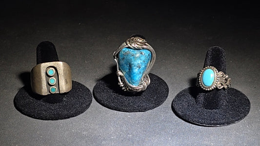 Trio of Vintage Southwestern Unmarked Sterling Silver and Turquoise Rings including Three-Dot Wide Band, Wire-Wrapped Stone, and Scrollwork Oval Cabochon