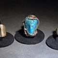 Lot 036 - Trio of Vintage Southwestern Unmarked Sterling Silver and Turquoise Rings Including Three-Dot Wide Band, Wire-Wrapped Stone, and Scrollwork Oval Cabochon, Total Weight 46.16 g