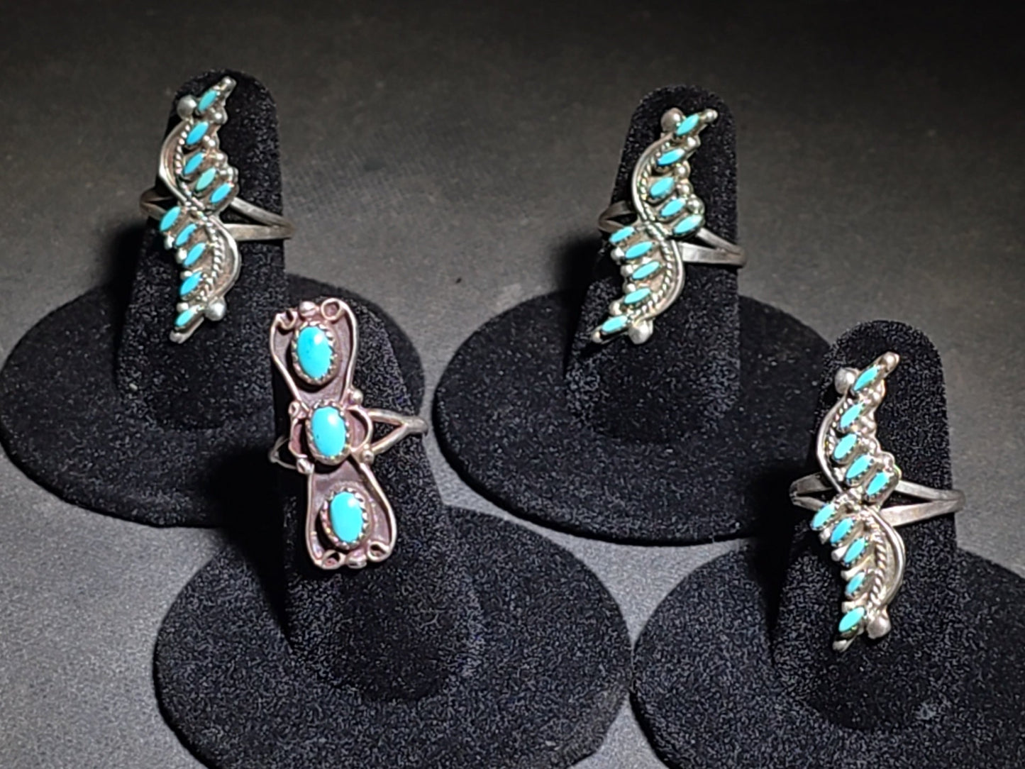 Grouping of Four Vintage Southwestern Sterling Silver and Turquoise Rings including Three Matching Petit Point Leaf Rings and a Three-Stone Oval Cabochon Ring
