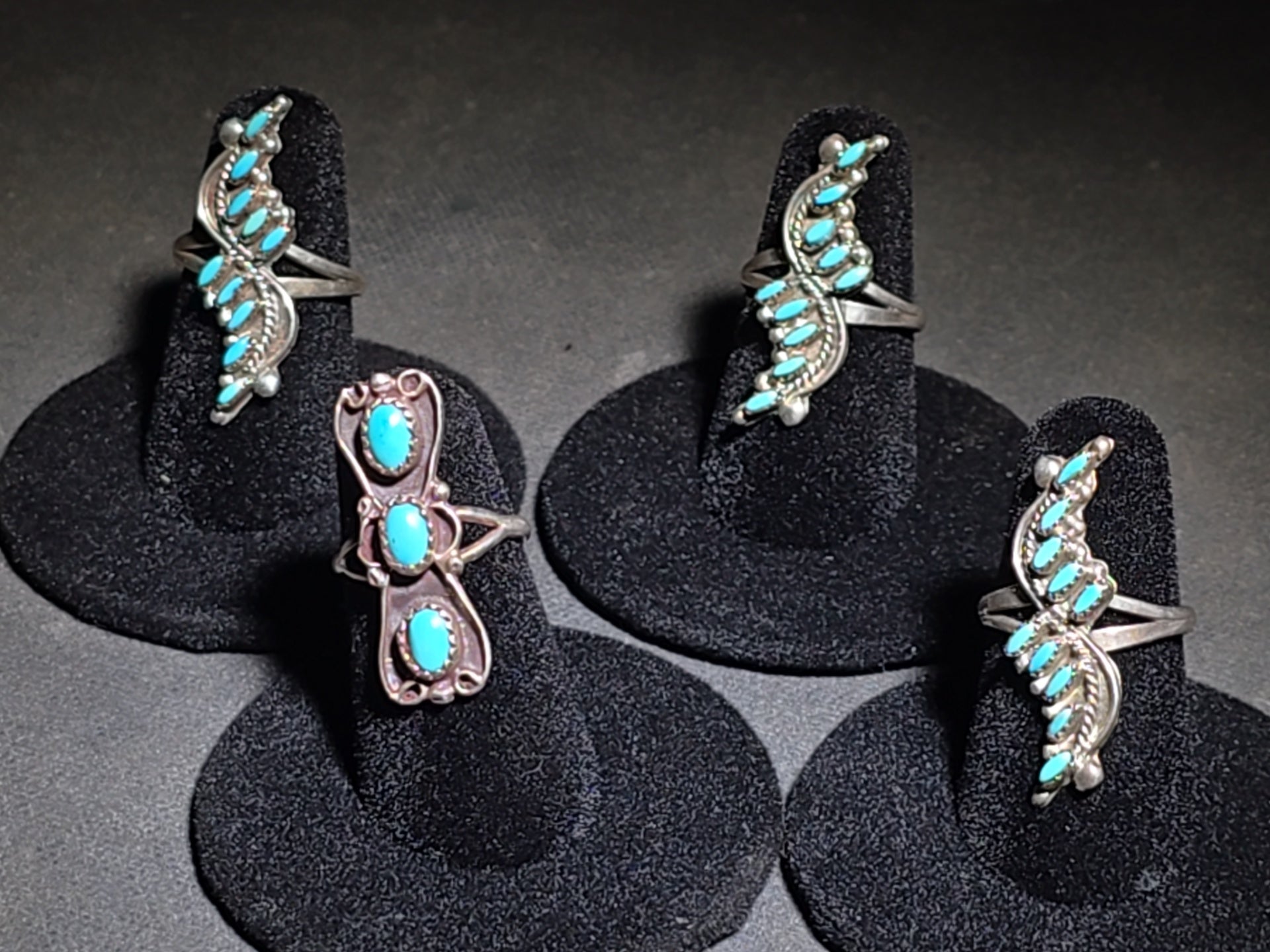 Grouping of Four Vintage Southwestern Sterling Silver and Turquoise Rings including Three Matching Petit Point Leaf Rings and a Three-Stone Oval Cabochon Ring