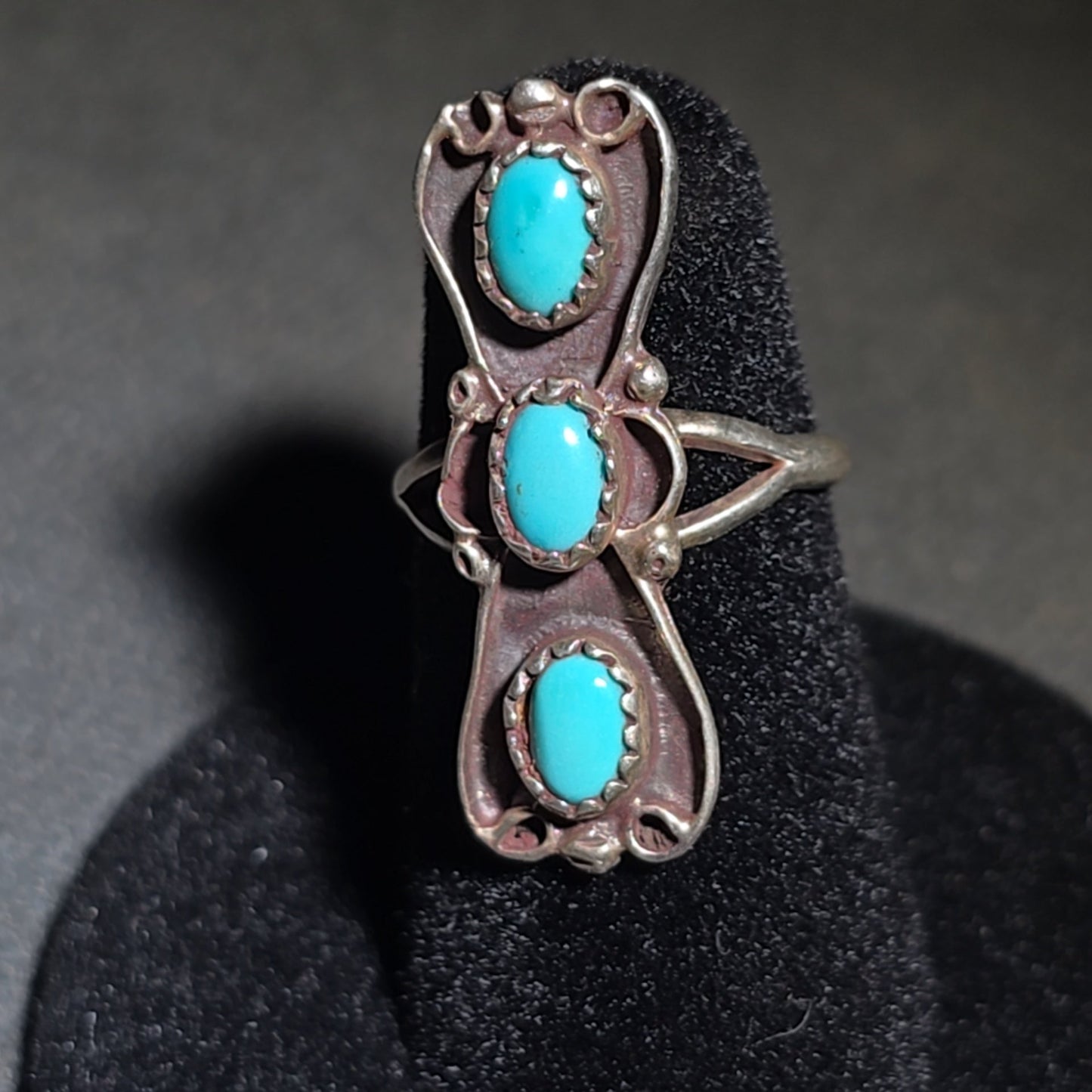 Grouping of Four Vintage Southwestern Sterling Silver and Turquoise Rings including Three Matching Petit Point Leaf Rings and a Three-Stone Oval Cabochon Ring