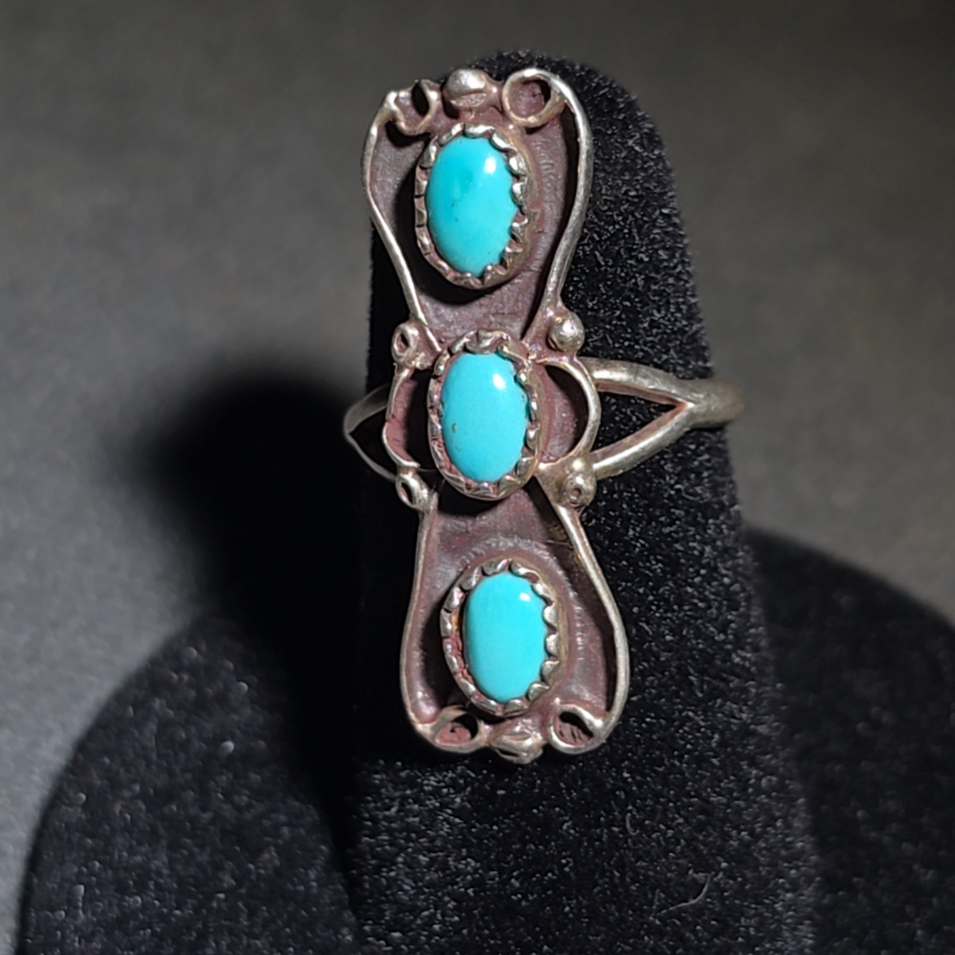 Grouping of Four Vintage Southwestern Sterling Silver and Turquoise Rings including Three Matching Petit Point Leaf Rings and a Three-Stone Oval Cabochon Ring