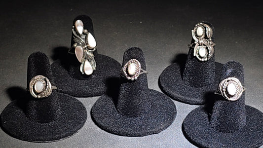 Grouping of Five Vintage Navajo Silver and Mother of Pearl Rings including a Four-Stone Ring by Les Hill, Sizes four through Seven