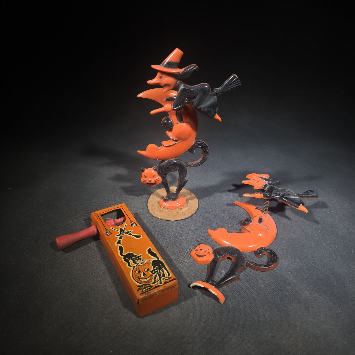 Grouping of Three Vintage Halloween Items including Tin Lithograph Ratchet Noisemaker with Jack-O-Lantern, Black Cat, and Witch Graphics, Manufactured by Kirchhof, Newark, New Jersey, and Two Witch on Crescent Moon and Black Cat Figures
