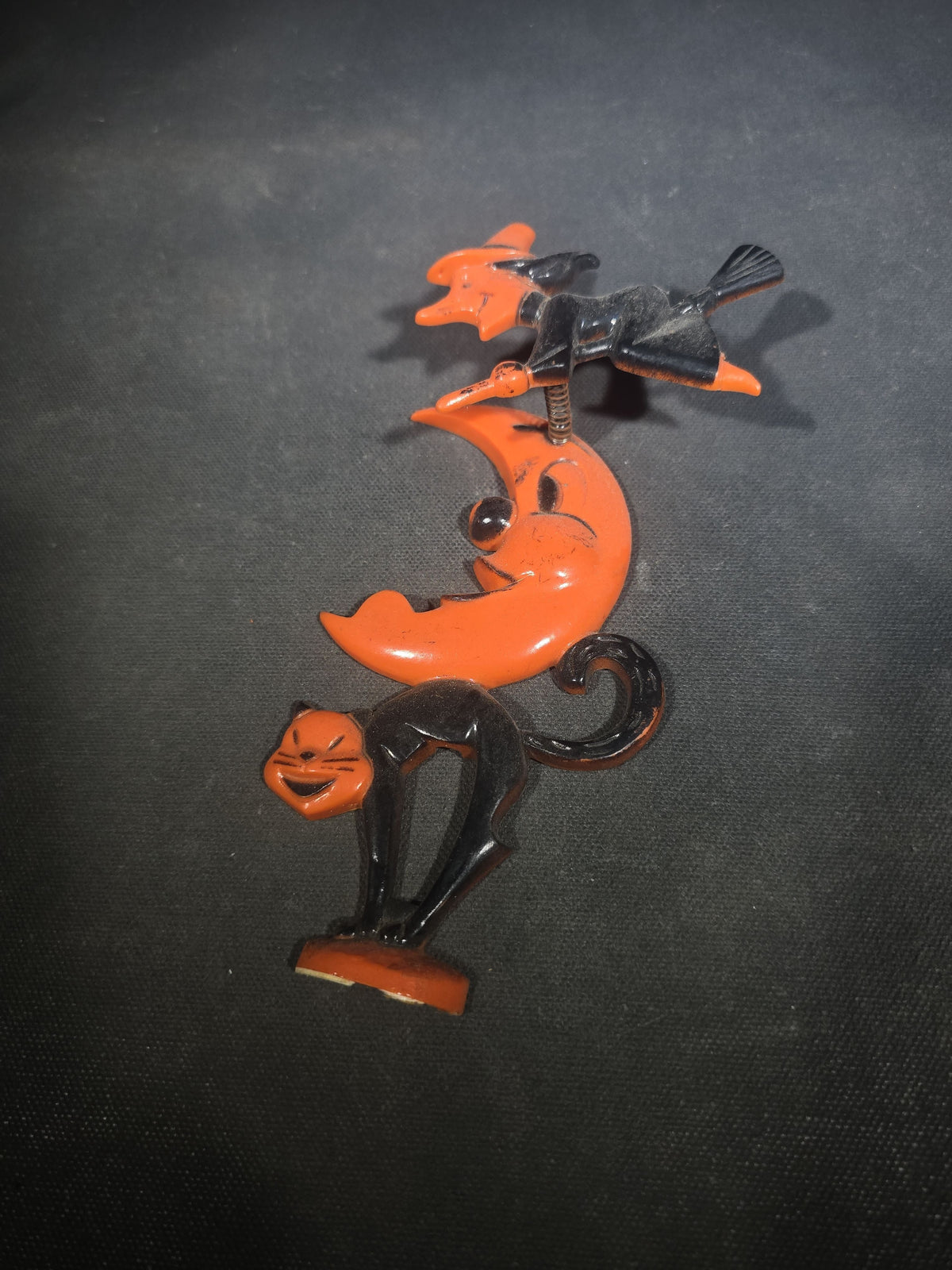 Grouping of Three Vintage Halloween Items including Tin Lithograph Ratchet Noisemaker with Jack-O-Lantern, Black Cat, and Witch Graphics, Manufactured by Kirchhof, Newark, New Jersey, and Two Witch on Crescent Moon and Black Cat Figures