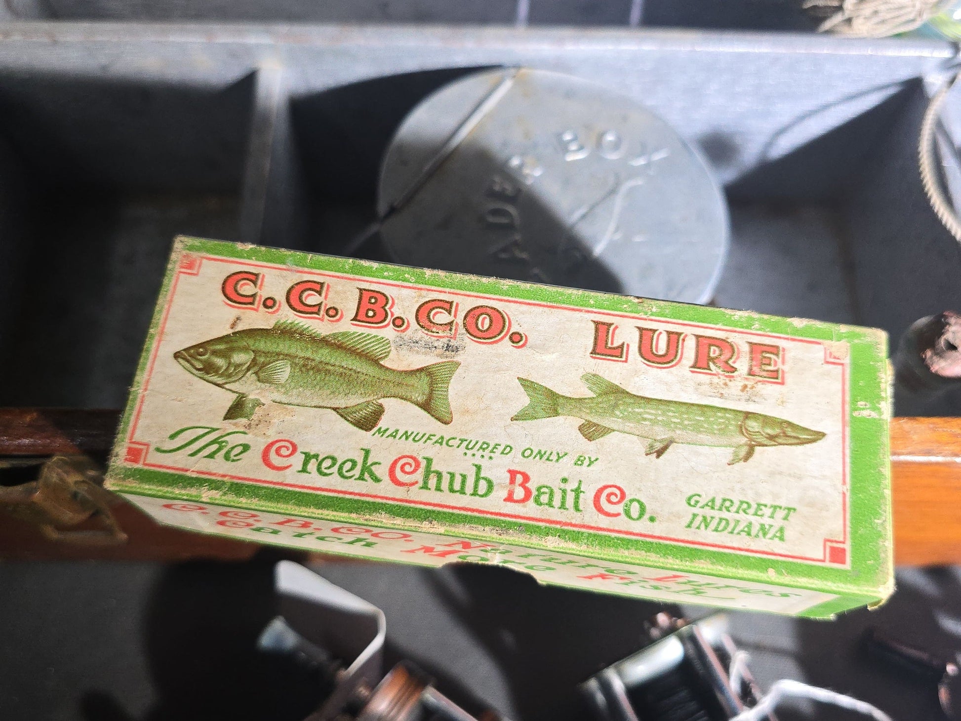 Vintage Wood Tackle Box with Fishing Tackle and Smalls including Creek Chub Bait Co. Injured Minnow Lure, Fly Fishing Flies, Baitcasting Reels, Leader Box, Fly Reel, and Stag Semi-Paste Paint Advertising Miniature Wood Plane