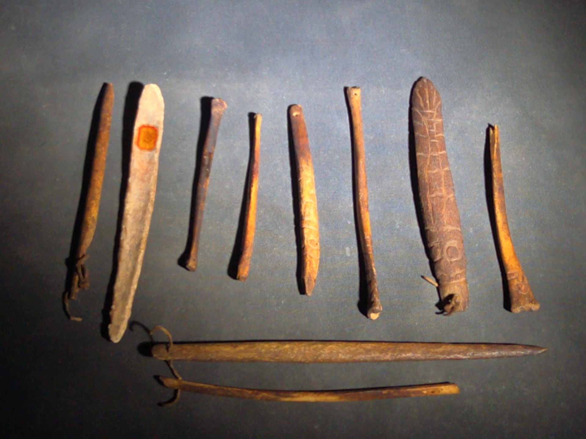 Grouping of 10 Antique Native American Carved Bone Implements including Incised and Relief-Carved Examples with Leather Ties and Drilled Holes