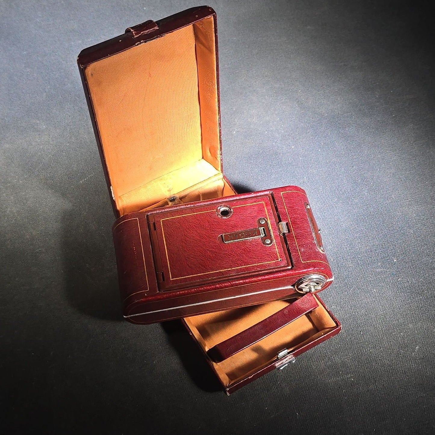 Pair of Antique and Vintage Kodak Folding Cameras including No. 1A Pocket Kodak Series II in Red with Kodak Anastigmat Lens and Kodak Retina 35mm Camera with Schneider-Kreuznach Xenar Lens, Compur-Rapid Shutter, and Leather Case
