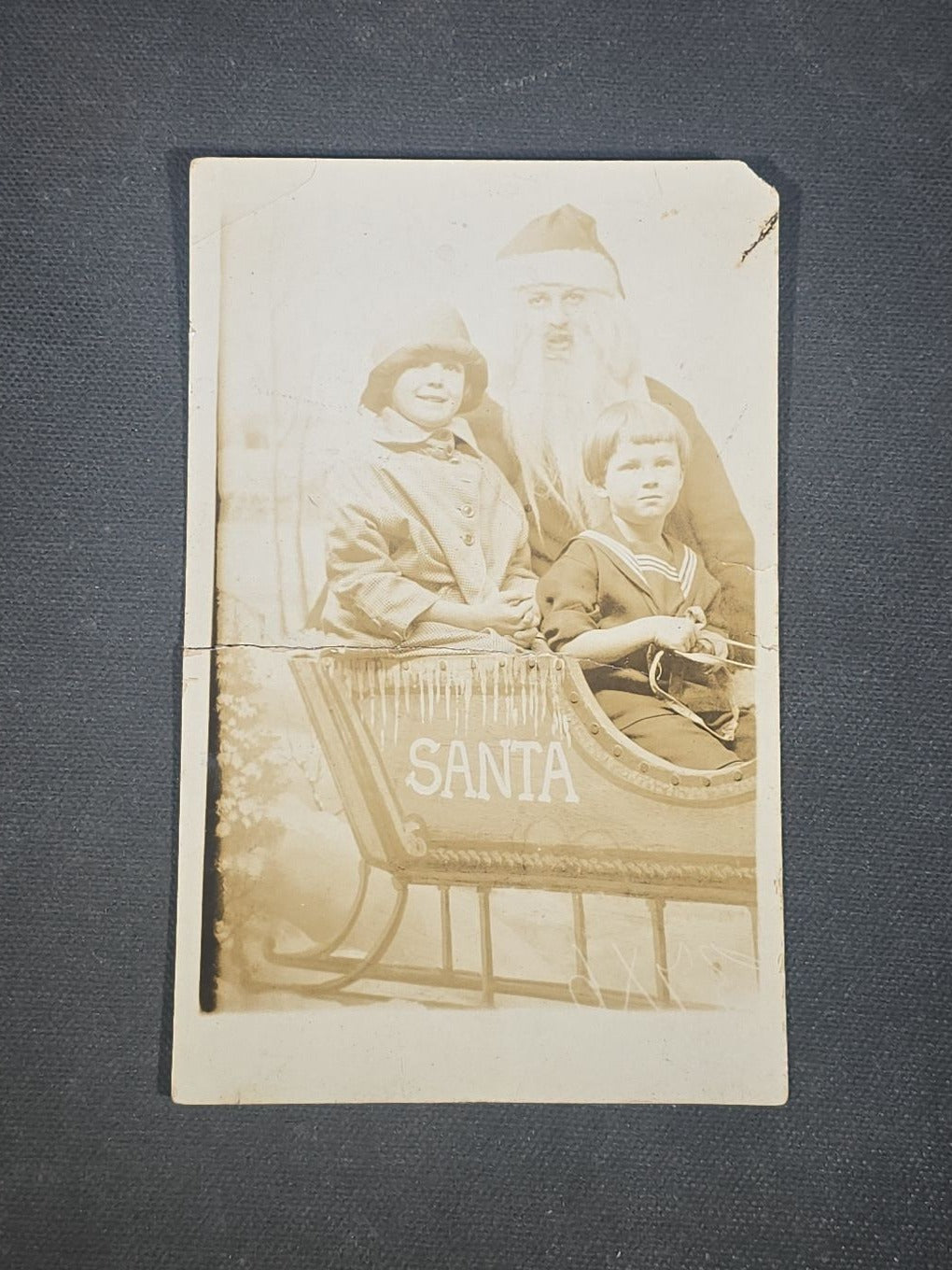 Grouping of Seven Antique and Vintage Christmas Ephemera including Santa Claus with Children in Sleigh R.P.P.C., Quincy Savings Bank Die-Cut Stocking Dime Holder, Personal Finance Company Advertising Needle Case, and Anti-New Deal Humorous Poem