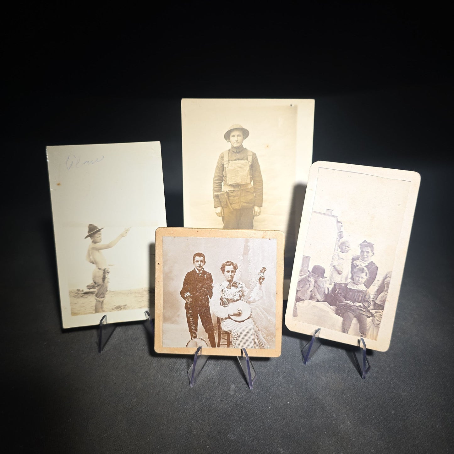 Grouping of Four Antique and Vintage Photographs including C.D.V. Family Portrait with Cat, WWI Soldier R.P.P.C., Board-Mounted Musicians with Violin and Banjo, and Snapshot of Child Cowboy