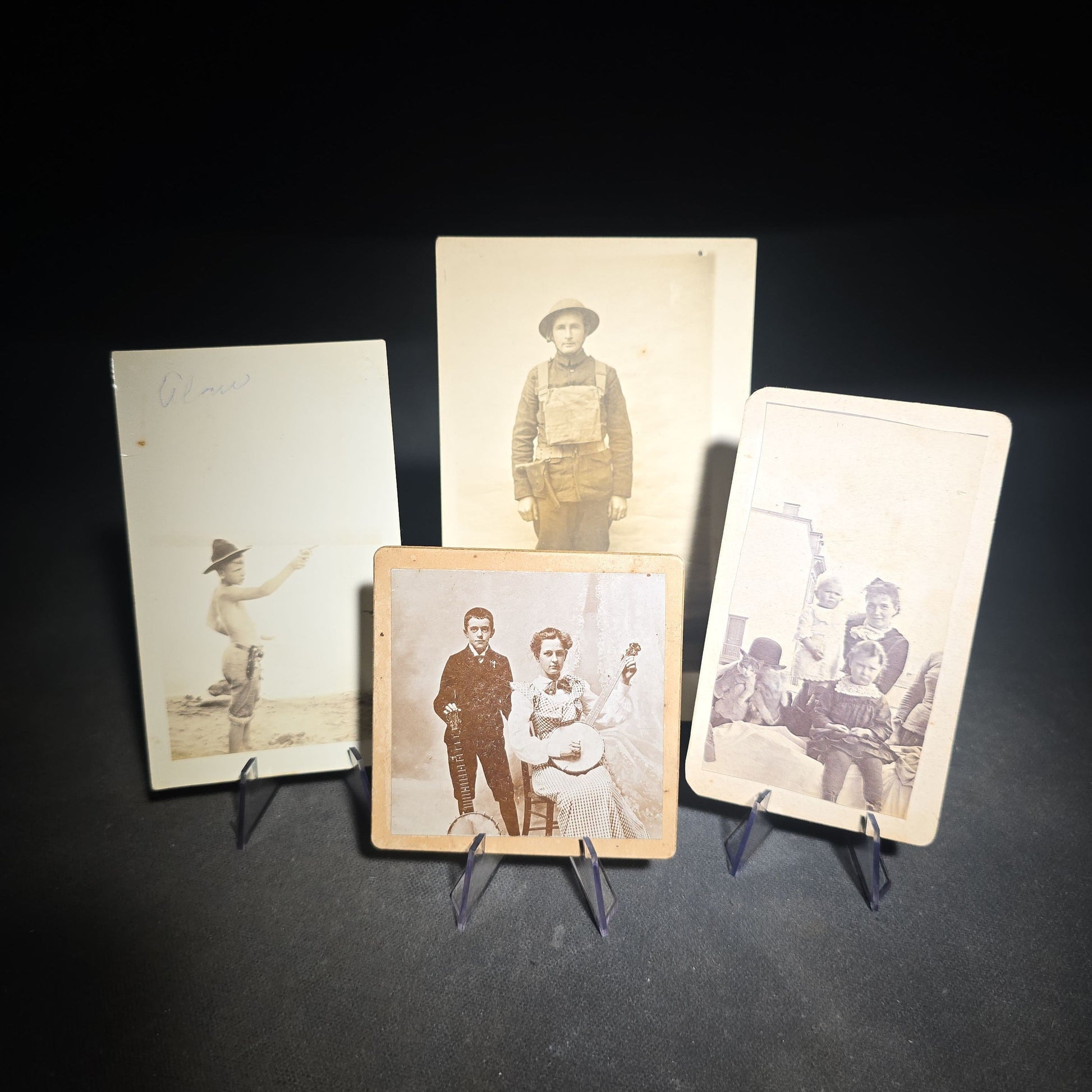 Grouping of Four Antique and Vintage Photographs including C.D.V. Family Portrait with Cat, WWI Soldier R.P.P.C., Board-Mounted Musicians with Violin and Banjo, and Snapshot of Child Cowboy