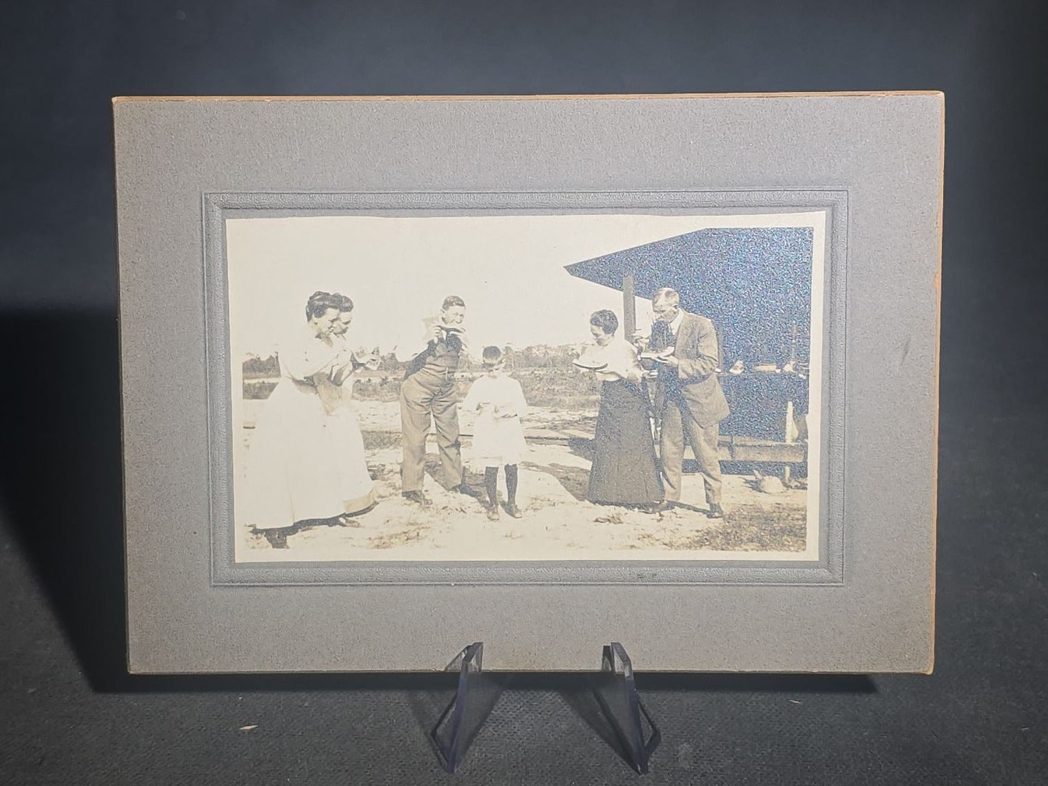 Grouping of Five Antique and Vintage Board-Mounted Photographs including Boy Holding a Box Camera, Two Men in Uniform, Family Eating Watermelon, and Dog Looking Out a Window, One Photographed by Rogers, New Haven, Connecticut