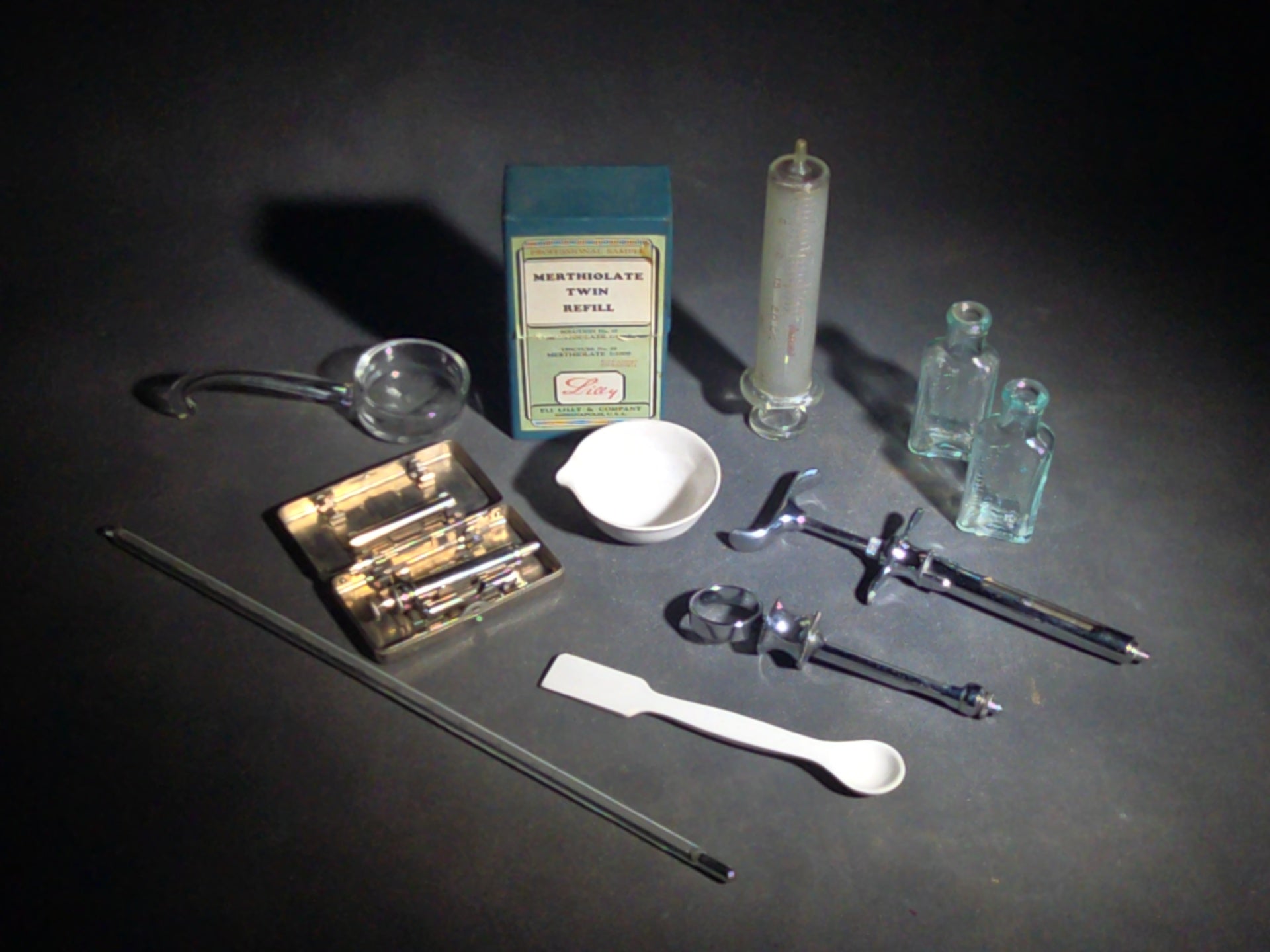 Grouping of Vintage Dental and Medical Pieces including Eli Lilly Merthiolate Twin Refill Box, Glass Syringe, and Chrome Dental Aspirating Syringe