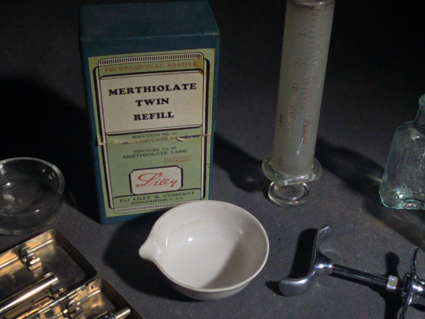 Grouping of Vintage Dental and Medical Pieces including Eli Lilly Merthiolate Twin Refill Box, Glass Syringe, and Chrome Dental Aspirating Syringe