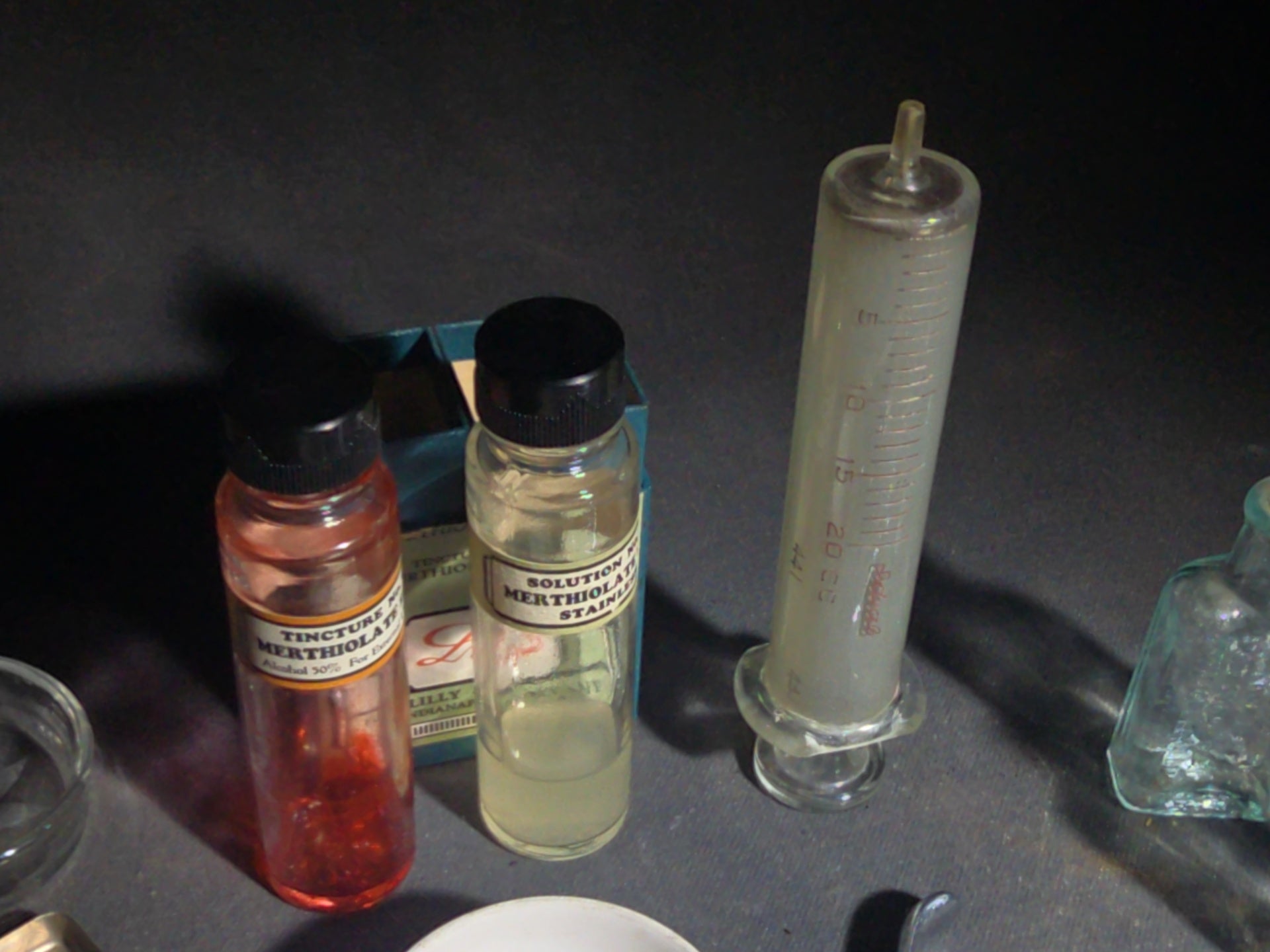 Grouping of Vintage Dental and Medical Pieces including Eli Lilly Merthiolate Twin Refill Box, Glass Syringe, and Chrome Dental Aspirating Syringe