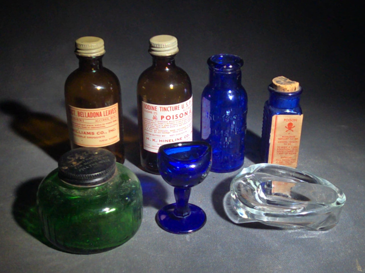 Grouping of Seven Antique and Vintage Apothecary Smalls including Belladona Leaves and Iodine Tincture Poison Bottles, Bichloride Mercury Poison Bottle, Cobalt Blue Eye Cup, and Sheaffer Skrip Ink Bottle
