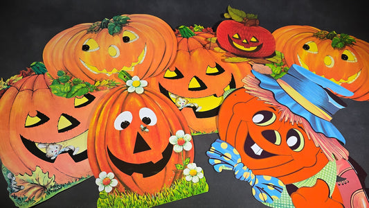 Grouping of Seven Vintage Die-Cut Halloween Jack-O-Lantern and Pumpkin Decorations including Jointed Pumpkin Scarecrow Figure