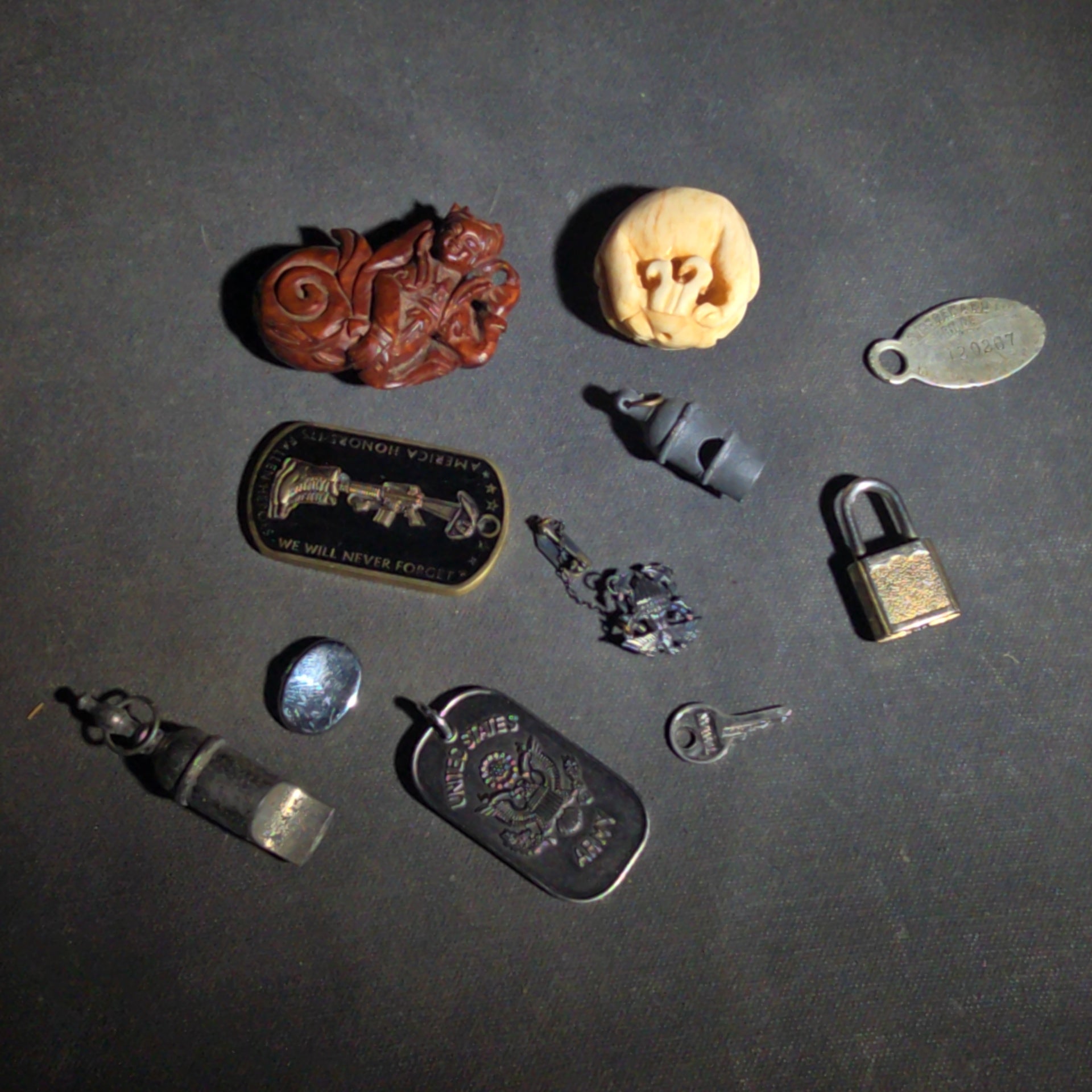 Grouping of Vintage and Modern Smalls including Carved Wood Figure, Carved Netsuke-Style Figure, U.S.M.C. Pin, United States Army Dog Tag Pendant, and Miniature Padlock