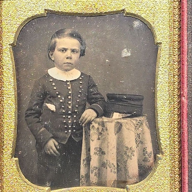 Antique 1/6th Plate Daguerreotype Photograph of a Child Standing Beside a Cloth-Covered Table with a Cap in Full Intact Leatherette Union Case with Embossed Floral and Scroll Design