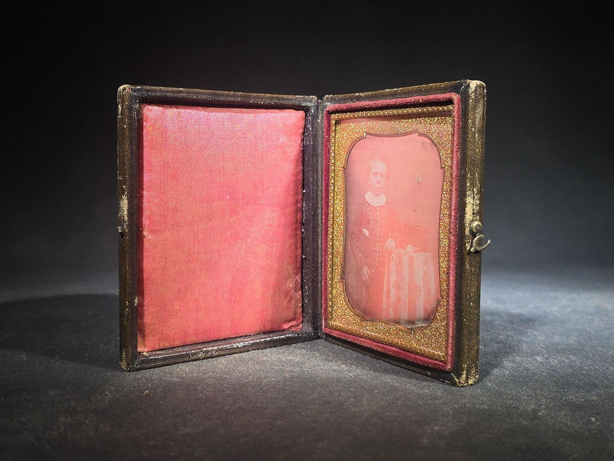 Antique 1/6th Plate Daguerreotype Photograph of a Child Standing Beside a Cloth-Covered Table with a Cap in Full Intact Leatherette Union Case with Embossed Floral and Scroll Design
