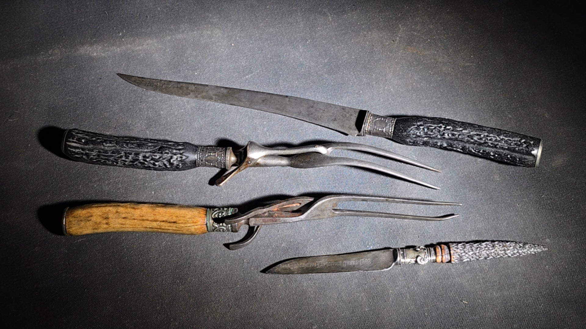 Grouping of Four Antique Carving Pieces including Trans-Mississippi Exposition Omaha 1898 Souvenir Knife, Stag-Handle Carving Knife and Fork, and Wood-Handle Carving Fork
