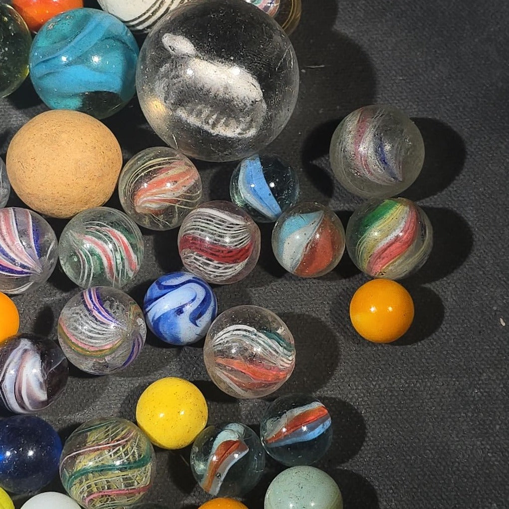 Grouping of 65+ Antique and Vintage Glass Marbles including Handmade German Swirls, Sulphide with Animal Figure, China, Clay, and UV-Reactive Glowing Examples