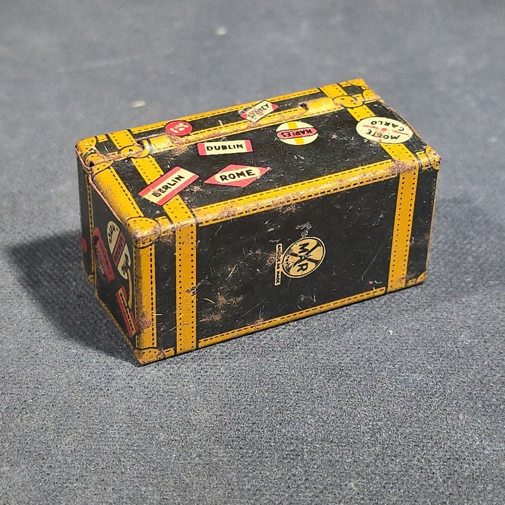 Grouping of Four Antique and Vintage Tin Lithograph Miniature Toys including Student at Desk, Two Miniature Travel Suitcases with Hotel and Travel Labels, and Pair of Seated Figures in Helmets
