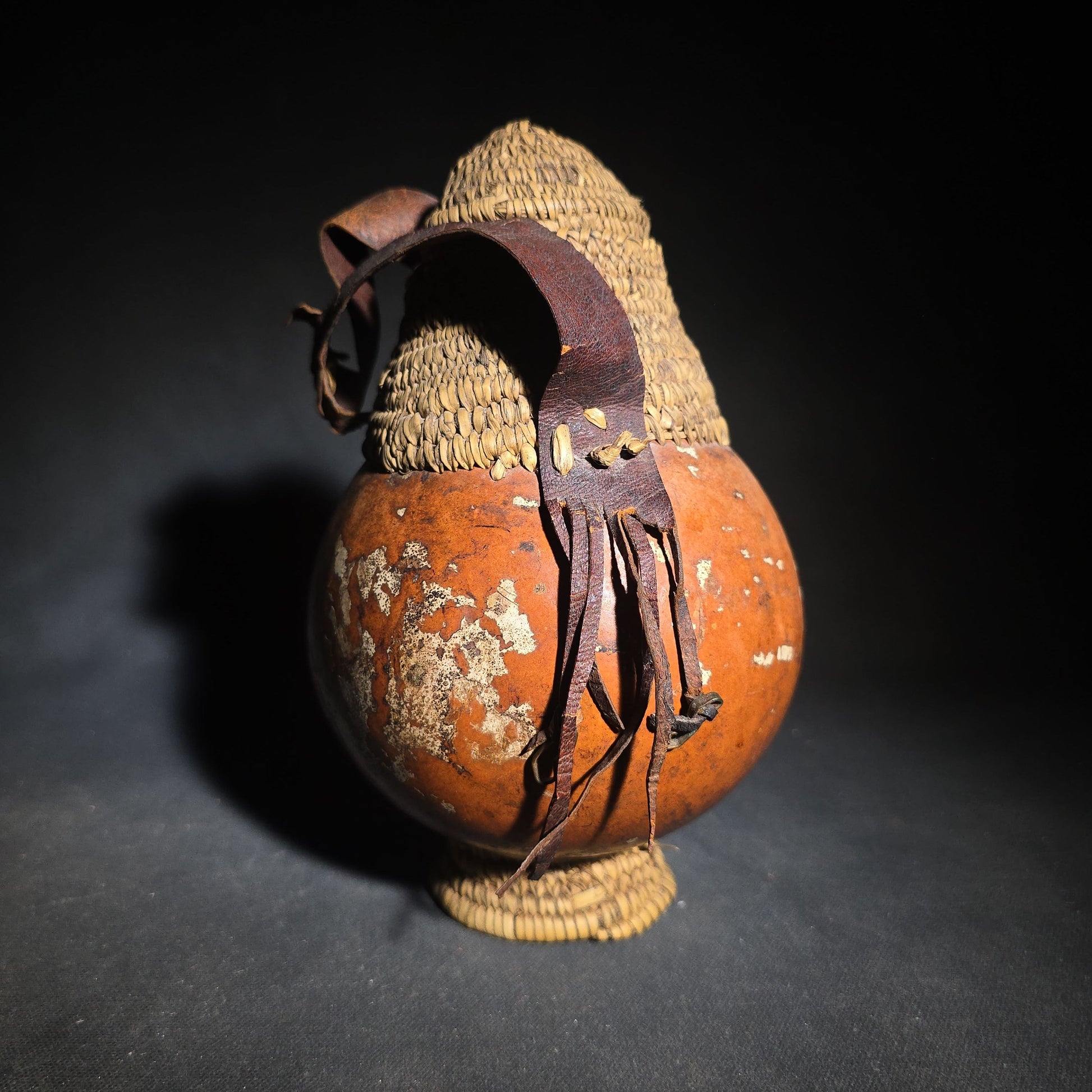 Pair of Vintage Woven Baskets including a Gourd Vessel with Leather Strap and Woven Stopper and a Coiled Lidded Basket