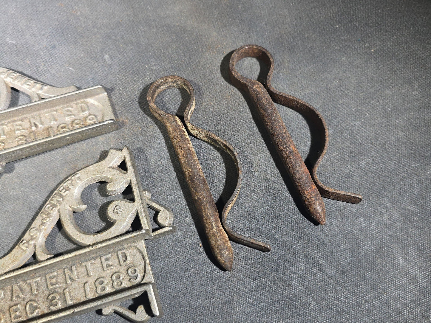 Grouping of Seven Antique Iron Hardware Pieces including Four R.S. Jewett Ornate Shelf Brackets Patented December 31, 1889, a Swivel Ring, and Two Cotter Pins