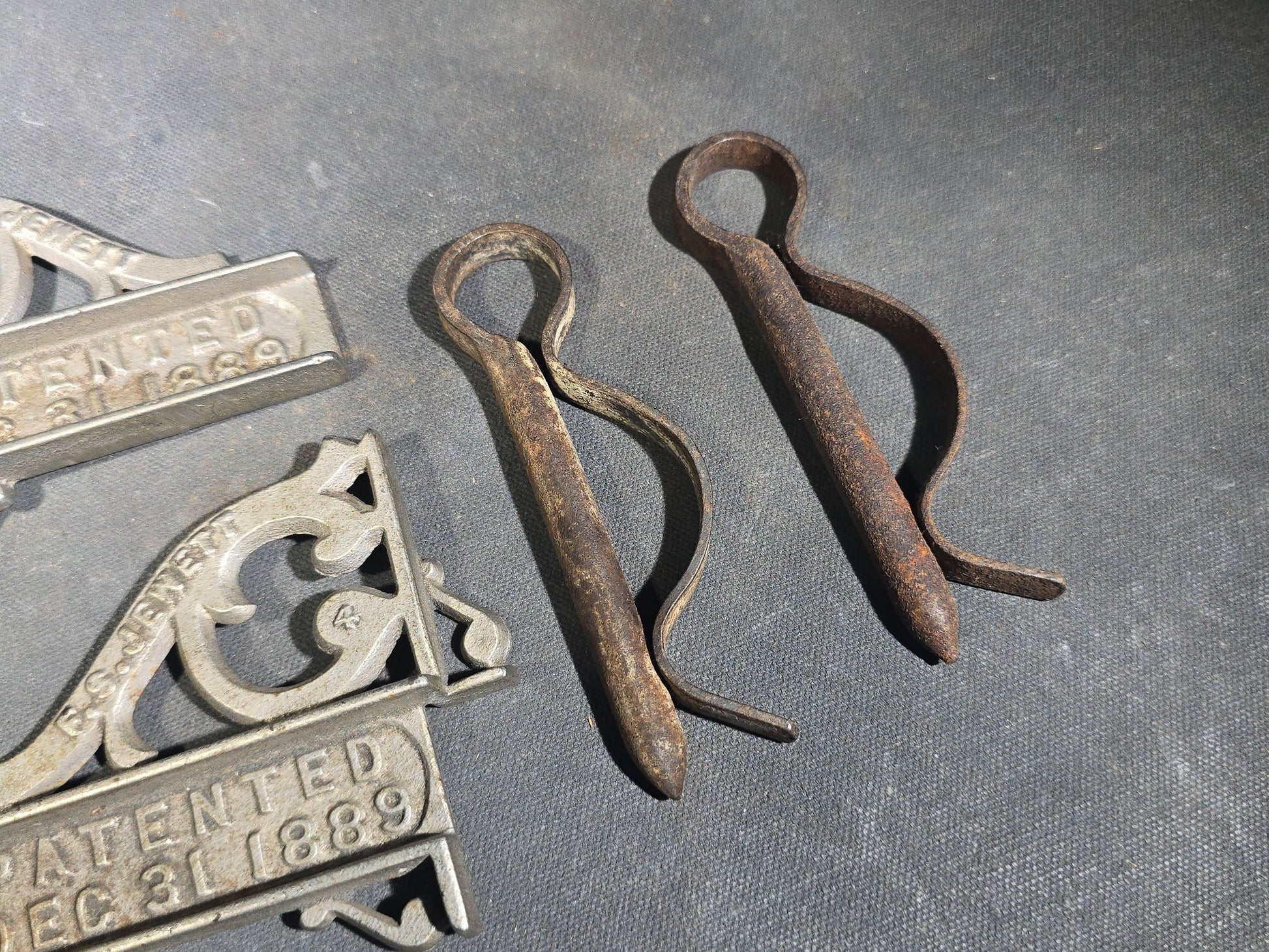 Grouping of Seven Antique Iron Hardware Pieces including Four R.S. Jewett Ornate Shelf Brackets Patented December 31, 1889, a Swivel Ring, and Two Cotter Pins