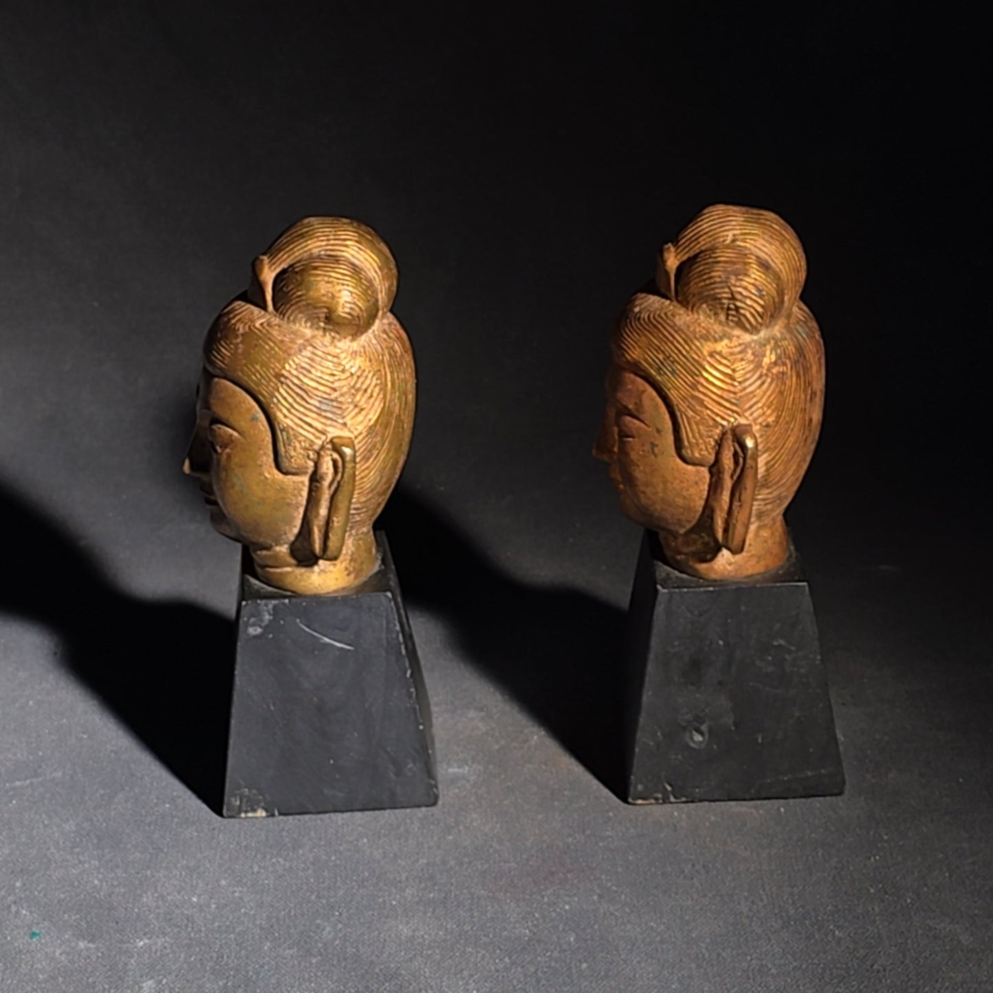Grouping of Four Vintage Brass Pieces including Pair of Gilt Bodhisattva Head Busts on Stands and Pair of Korean Folding Bookends with Pagoda Gate Design