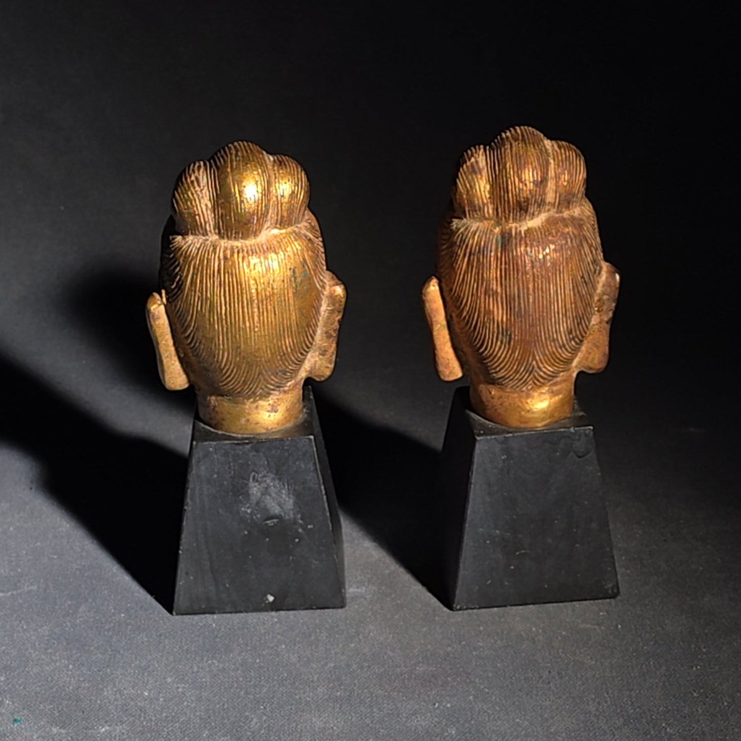 Grouping of Four Vintage Brass Pieces including Pair of Gilt Bodhisattva Head Busts on Stands and Pair of Korean Folding Bookends with Pagoda Gate Design