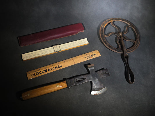 Grouping of Four Antique and Vintage Tools including Swordfish Brand Multi-Tool Hatchet, Frederick Post Co. Slide Rule with Case, Advertising Wooden Ruler, and Cast Iron Measuring Wheel
