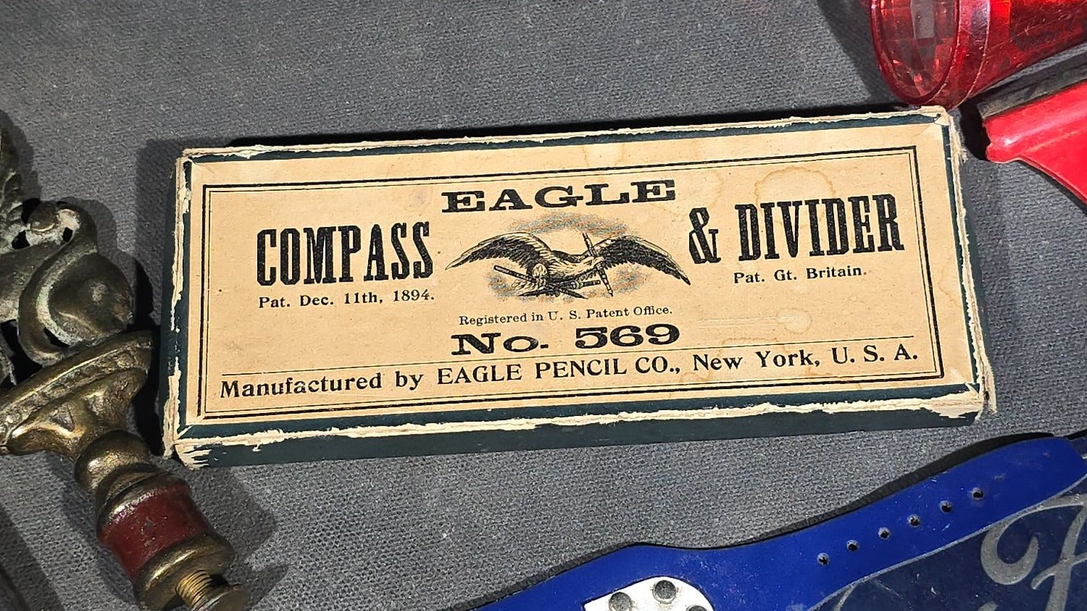 Grouping of Antique and Vintage Junk Drawer Smalls including Eagle Pencil Co. Compass Box, Ford Key Fob, Military Medals and Belt Buckle, Eyeglasses, Match Safe, and Pinback Buttons
